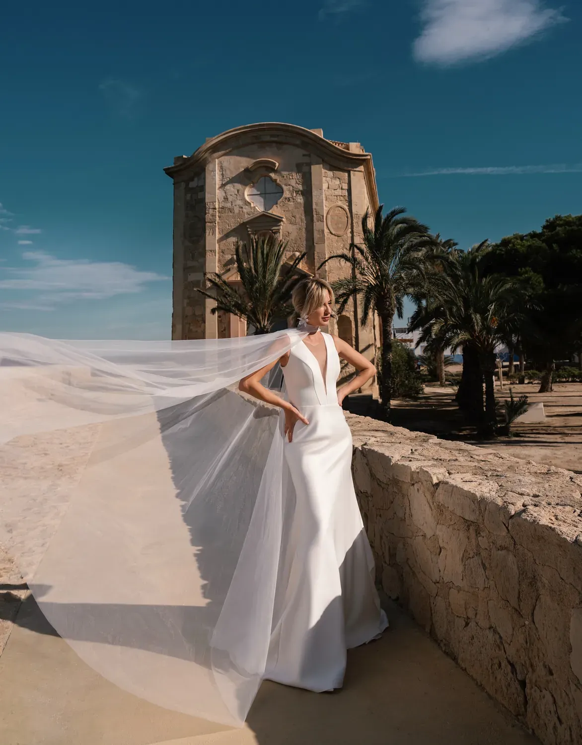 Vestido Levante, cuerpo halter de crepe frente a la torre de piedra